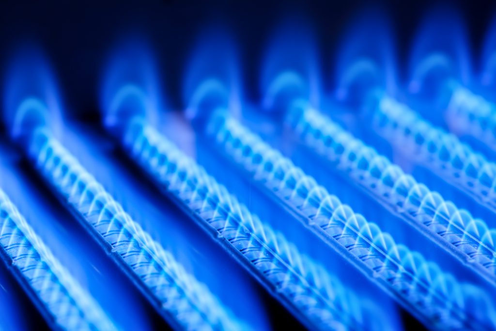 Blue flames of a gas burner inside of a boiler